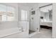 Newly remodeled bathroom features a modern bathtub and a glass enclosed shower, with marble tiling and stone accents at 45 W Fremont Pl, Littleton, CO 80120