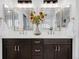 A marble countertop vanity is decorated with flowers and features a double sink with gold framed mirrors above at 45 W Fremont Pl, Littleton, CO 80120