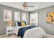 Cozy bedroom with blue and yellow accents, featuring a sunflower painting, three windows, and natural light at 45 W Fremont Pl, Littleton, CO 80120