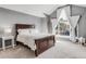 A bedroom features vaulted ceiling, a large window with white drapes, a decorative ladder, and a dark wood bed at 45 W Fremont Pl, Littleton, CO 80120