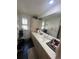 Bright bathroom featuring a long vanity with ample countertop space, a sink, and storage cabinets at 14141 E Baltic Pl, Aurora, CO 80014