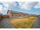 Well-maintained backyard featuring a green lawn, gravel landscaping, and a charming exterior view at 56432 E 23Rd Ave, Strasburg, CO 80136