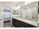 Bathroom with double sinks, granite countertop, and large mirror above vanity at 56432 E 23Rd Ave, Strasburg, CO 80136
