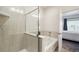Bathroom with separate shower and soaking tub with neutral tile and a glass door at 56432 E 23Rd Ave, Strasburg, CO 80136