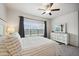 Bright bedroom featuring a ceiling fan and a large window with backyard views at 56432 E 23Rd Ave, Strasburg, CO 80136