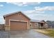 Exterior shot of house shows a spacious garage and well-maintained lawn at 56432 E 23Rd Ave, Strasburg, CO 80136