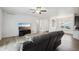 Bright living room featuring wood floors, ceiling fan, and large windows for ample natural light at 56432 E 23Rd Ave, Strasburg, CO 80136