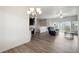 Living room with wood floors and view into the kitchen and sliding glass doors at 56432 E 23Rd Ave, Strasburg, CO 80136