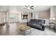 Open-concept living room with wood floors, a ceiling fan, and access to the kitchen at 56432 E 23Rd Ave, Strasburg, CO 80136
