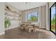 Dining room featuring modern light fixture, wood floors, and floating shelves for decorative display at 1465 Gentle Rain Dr, Castle Rock, CO 80109