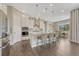 Eat-in kitchen with hardwood floors, pendant lights, counter seating and white cabinets at 1465 Gentle Rain Dr, Castle Rock, CO 80109