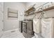 Well-lit laundry room featuring modern appliances, overhead storage, and charming decor at 1465 Gentle Rain Dr, Castle Rock, CO 80109