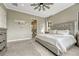 Comfortable main bedroom with neutral colors, tufted headboard, and doorway to the ensuite bath at 1465 Gentle Rain Dr, Castle Rock, CO 80109