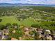 Aerial view of a property surrounded by lush greenery with mountain views in the distance at 6982 Estes Dr, Arvada, CO 80004