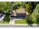 Aerial view of a charming green home, lush backyard, and a driveway at 6982 Estes Dr, Arvada, CO 80004