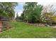 Spacious backyard features lush lawn, mature trees, and a charming gazebo at 6982 Estes Dr, Arvada, CO 80004