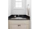 Bathroom vanity featuring dark granite countertops, neutral cabinets and modern fixtures at 6982 Estes Dr, Arvada, CO 80004
