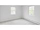 Bright bedroom featuring neutral carpet, fresh white paint, and two windows for natural light at 6982 Estes Dr, Arvada, CO 80004