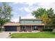 Inviting two-story home with brick accents, a well-maintained lawn, and mature trees at 6982 Estes Dr, Arvada, CO 80004