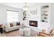 Bright living room with a white brick fireplace, built-in shelves, and stylish decor at 6982 Estes Dr, Arvada, CO 80004