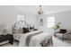 Bright main bedroom with fresh white walls, decorative chandelier, and large windows at 6982 Estes Dr, Arvada, CO 80004