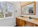 Bathroom featuring double sinks with wood cabinets and a window providing natural light at 9508 Elk Mountain Cir, Littleton, CO 80125