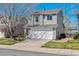 Charming two-story home featuring a two-car garage, driveway and view of the blue sky at 9508 Elk Mountain Cir, Littleton, CO 80125
