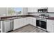 Bright kitchen featuring stainless steel appliances, white cabinets, dark countertops, and a stainless steel sink at 9508 Elk Mountain Cir, Littleton, CO 80125