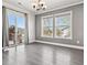 Bright living room featuring grey walls, new flooring, windows with a view, and sliding glass door to the outside deck at 9508 Elk Mountain Cir, Littleton, CO 80125