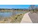 Picturesque view of a pond with a paved walking path and neighborhood playground in the background at 9508 Elk Mountain Cir, Littleton, CO 80125