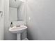 Clean powder room with a pedestal sink, large mirror, and modern fixtures at 9508 Elk Mountain Cir, Littleton, CO 80125