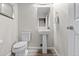Small bathroom featuring pedestal sink, toilet, framed mirror and wood-look floors at 16421 Askins Loop, Parker, CO 80134