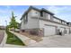 Exterior side view of townhome with garage, hardscaped yard, and lovely tree at 16421 Askins Loop, Parker, CO 80134