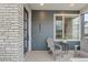 Inviting covered porch with seating area, stylish exterior paint, and modern architectural details at 16421 Askins Loop, Parker, CO 80134
