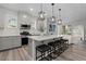 Stylish kitchen featuring gray cabinetry, stainless steel appliances, and a large island with modern pendant lighting at 16421 Askins Loop, Parker, CO 80134