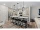 Open kitchen with a large center island, modern pendant lights, stainless appliances, and gray cabinetry at 16421 Askins Loop, Parker, CO 80134