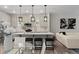 Contemporary kitchen with large island, black pendant lighting, stainless appliances, and open to living area at 16421 Askins Loop, Parker, CO 80134