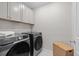 Modern laundry room features Samsung washer and dryer beneath upper cabinets at 16421 Askins Loop, Parker, CO 80134