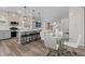 Bright kitchen and living area featuring a center island, pendant lighting, and a dining table at 16421 Askins Loop, Parker, CO 80134