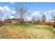Large, fenced backyard featuring a lush lawn and mature trees at 7604 S Lamar Ct, Littleton, CO 80128