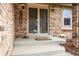 Welcoming front entrance with a brick facade, double doors, and a cozy porch with stylish sconces at 7604 S Lamar Ct, Littleton, CO 80128