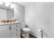 Neat half bathroom featuring a granite countertop and updated fixtures at 7604 S Lamar Ct, Littleton, CO 80128
