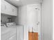 Bright laundry room with washer, dryer, storage, and adjacent to utility sink at 7604 S Lamar Ct, Littleton, CO 80128