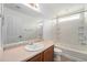 Traditional bathroom with a single sink vanity, framed mirror and shower-tub combination at 5572 Killarney St, Denver, CO 80249