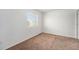 Cozy bedroom with neutral carpet, white walls, and a window offering natural light at 5572 Killarney St, Denver, CO 80249