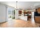 Open kitchen featuring tile floor, breakfast bar, wood cabinets, and sliding glass doors to backyard at 5572 Killarney St, Denver, CO 80249