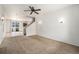 Bright living room with carpet, ceiling fan, and staircase leading to the second floor at 5572 Killarney St, Denver, CO 80249