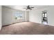 Spacious main bedroom with a large window, neutral carpet, and an en-suite bathroom at 5572 Killarney St, Denver, CO 80249