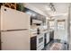 Functional kitchen featuring dark cabinets, white appliances, and tiled floor at 8168 Washington St # 46, Denver, CO 80229
