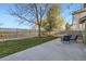 Private backyard featuring a concrete patio, grassy area, mature tree and wooden fence at 10984 Alcott Dr, Denver, CO 80234
